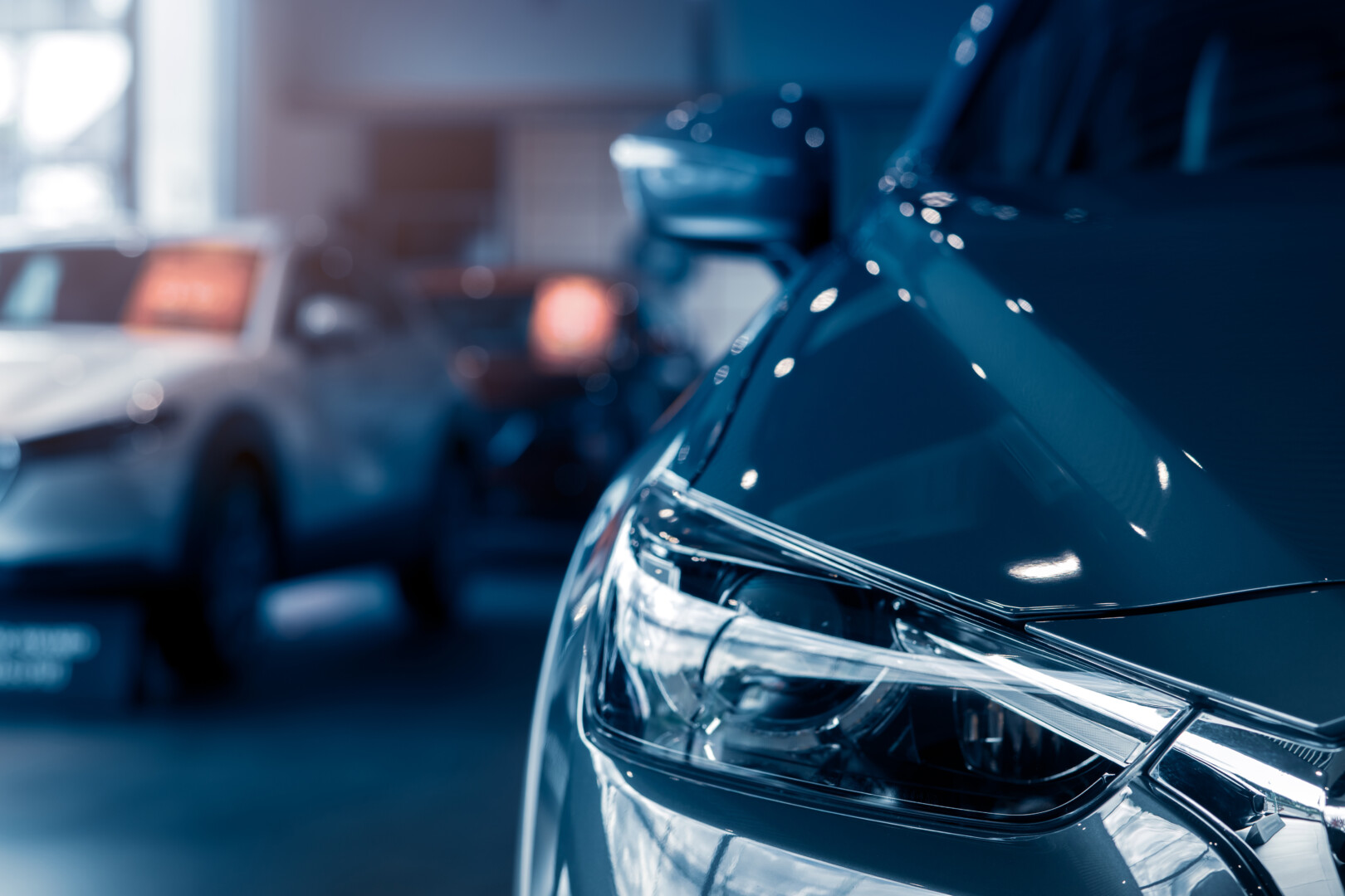 Selective focus grey car parked in luxury showroom. Car dealership office. New car parked in modern showroom. Car for sale and rent business concept. Automobile leasing and insurance background.